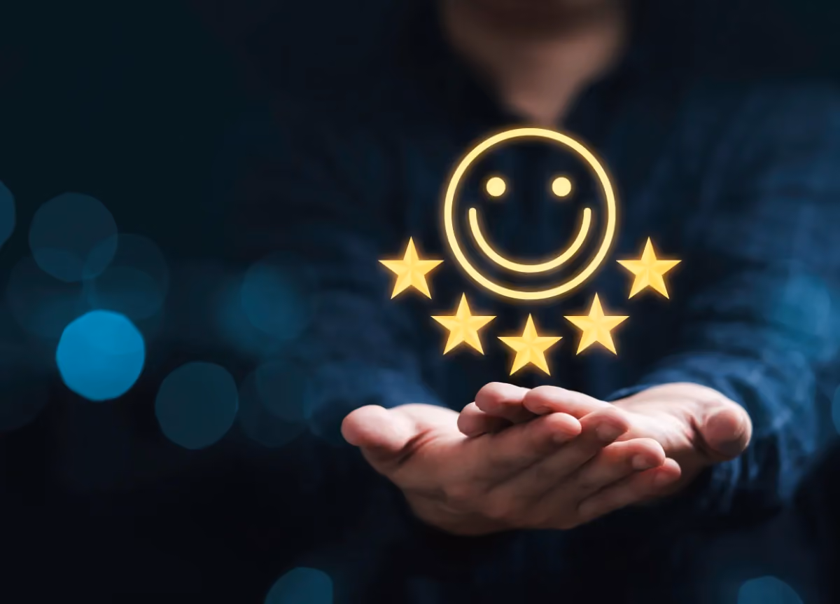Businessman holding hologram of smiley face and five stars above his hands