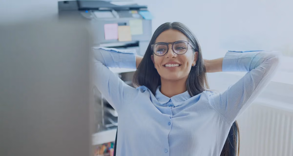 A woman leaning back in an office chair with her hands behind her head