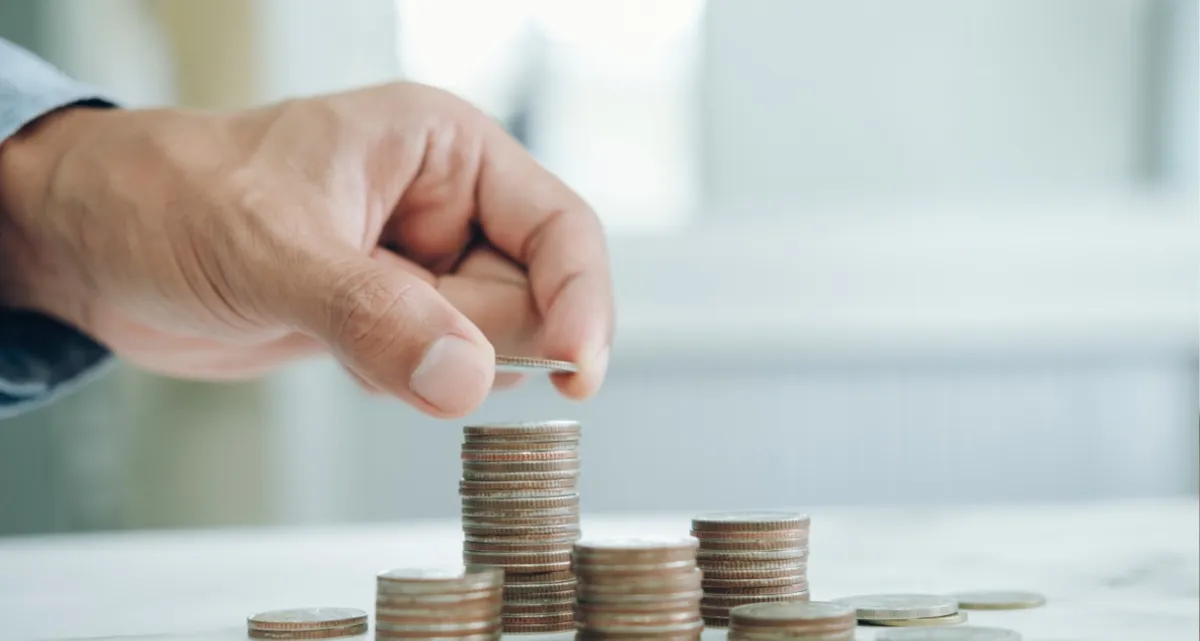 A hand stacking coins