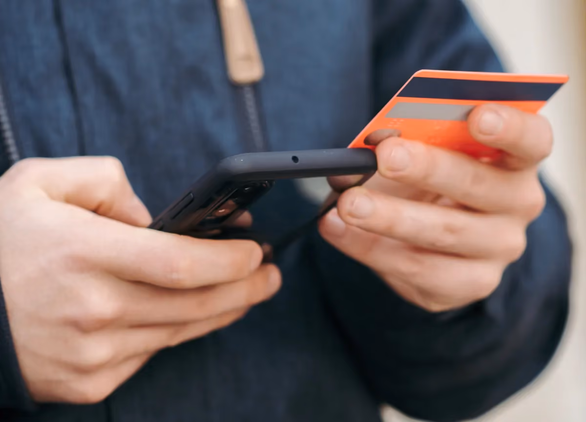 Man uses his credit card to make a digital payment on his cell phone