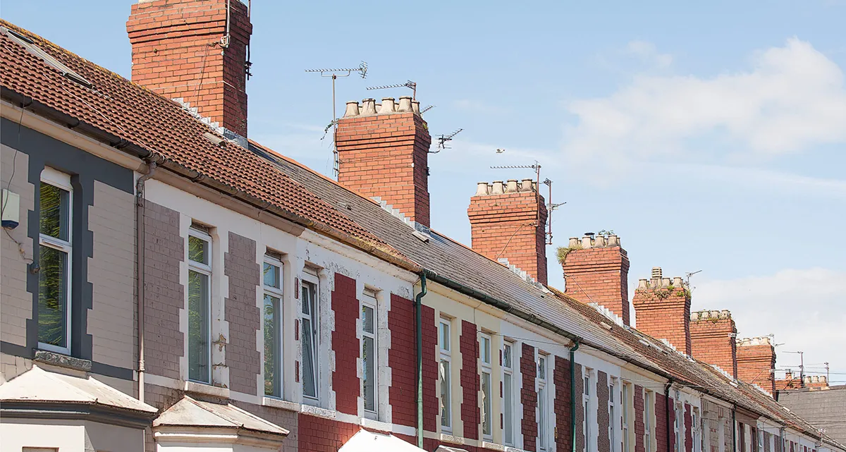 A row of colourful terraced houses with chimneys
