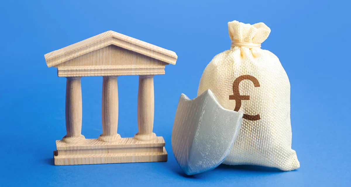 The front of a pillared building, a bag of money and a shield on a blue background.