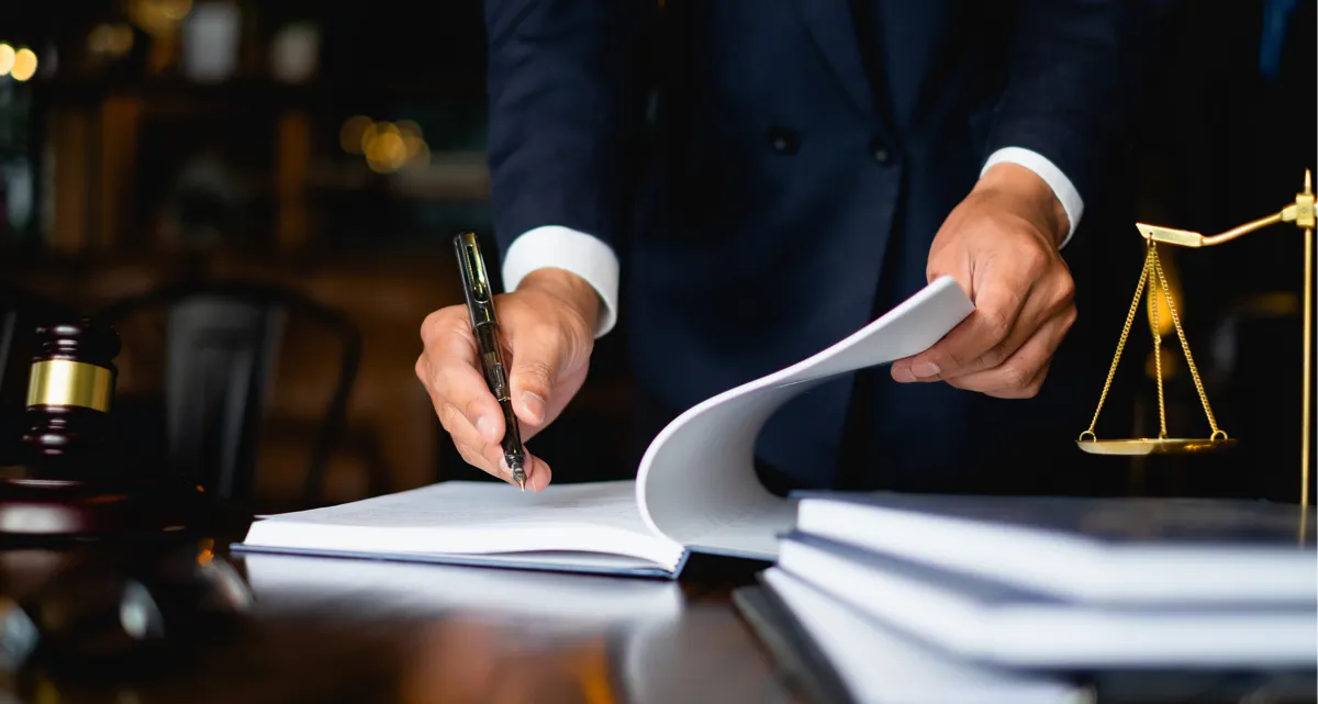 A man in a suit writing in a notebook