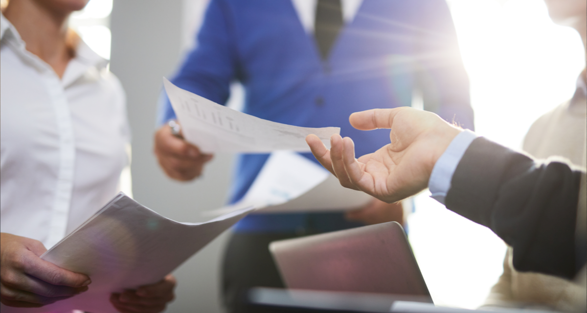 A person handing over a document to another person