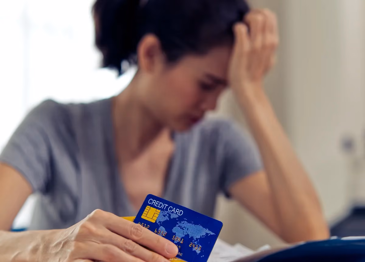 Distressed woman holding a credit card
