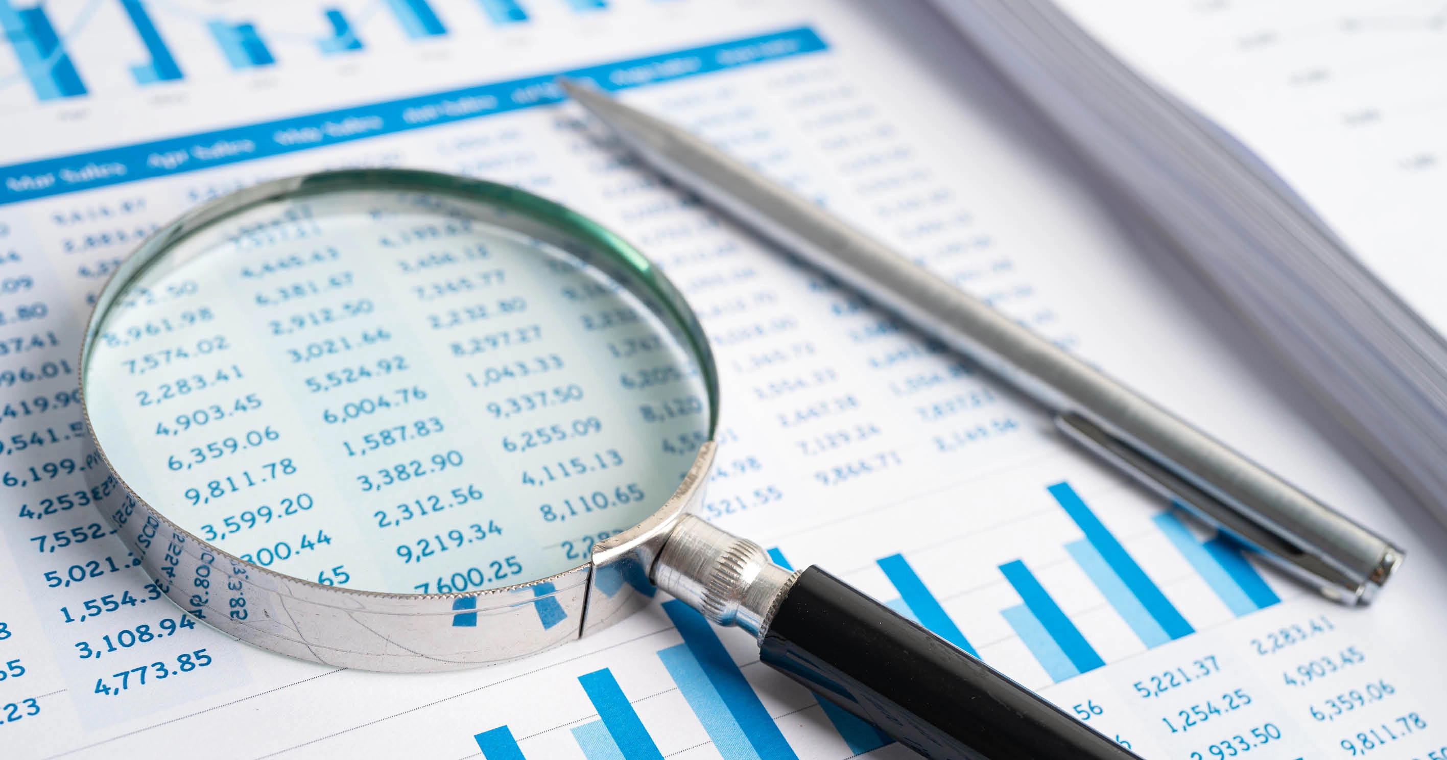 A magnifying glass on a table of figures