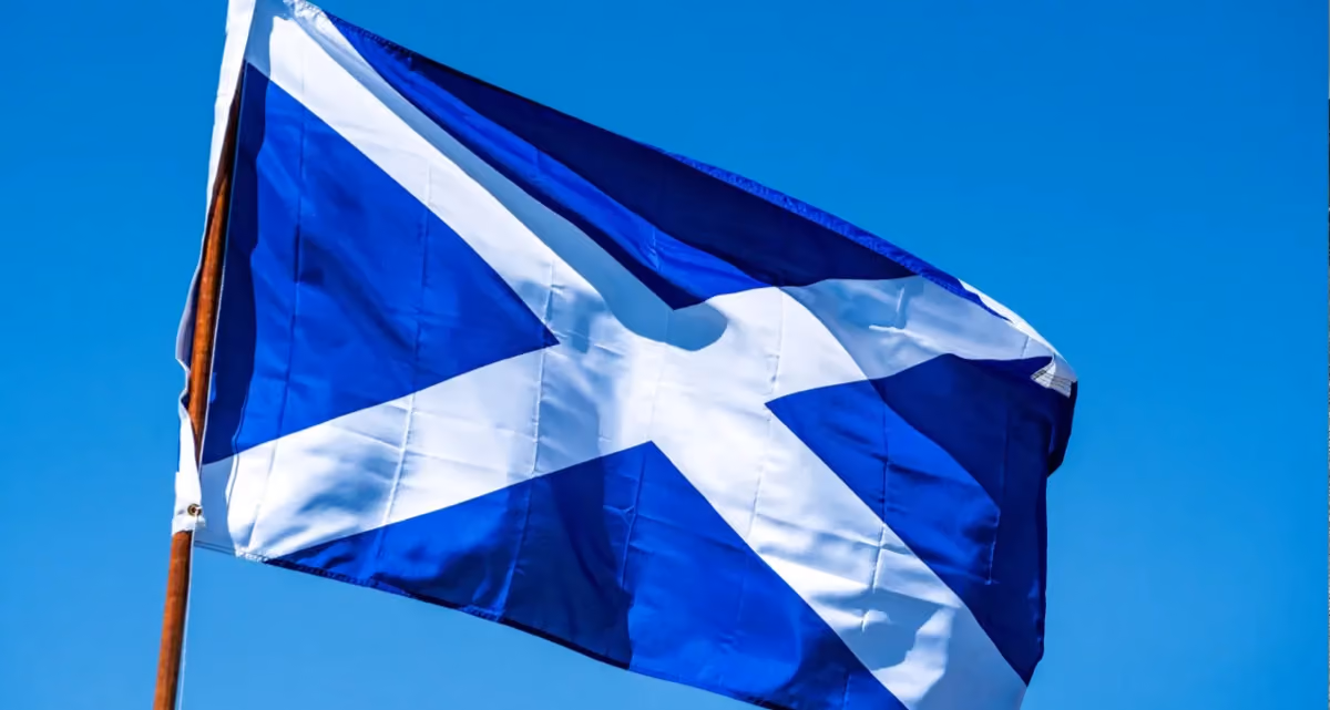 The flag of Scotland in front of a blue sky
