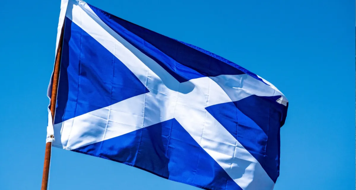 The flag of Scotland in front of a blue sky