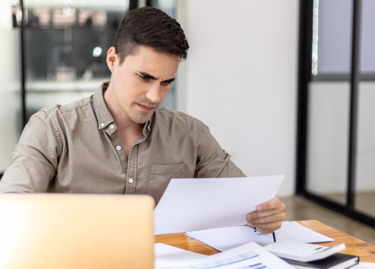 Man holding tax statements looks displeased