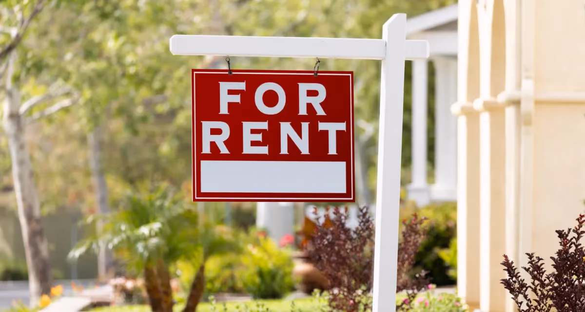 A red "For Rent" sign outside a home