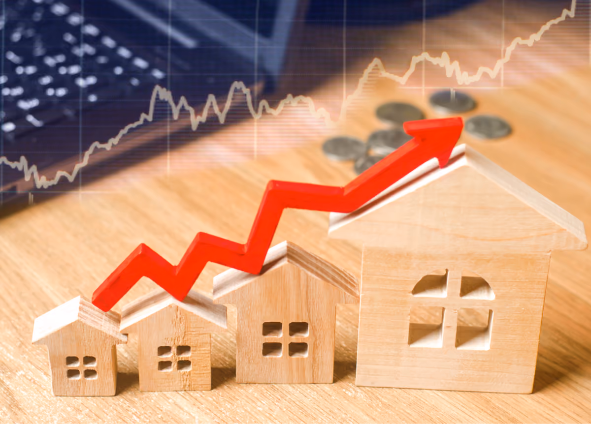 A red arrow pointing up on top of wooden models of homes.