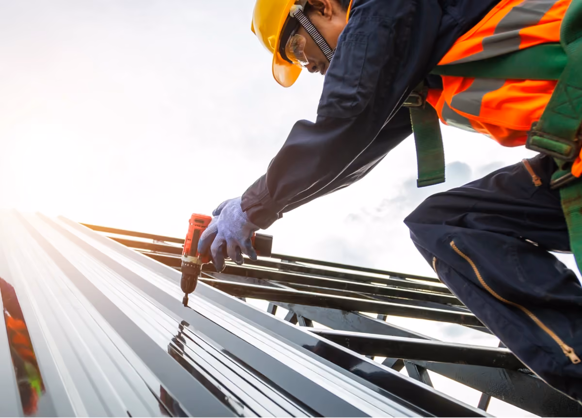 Construction worker using a power drill on construction site of new house