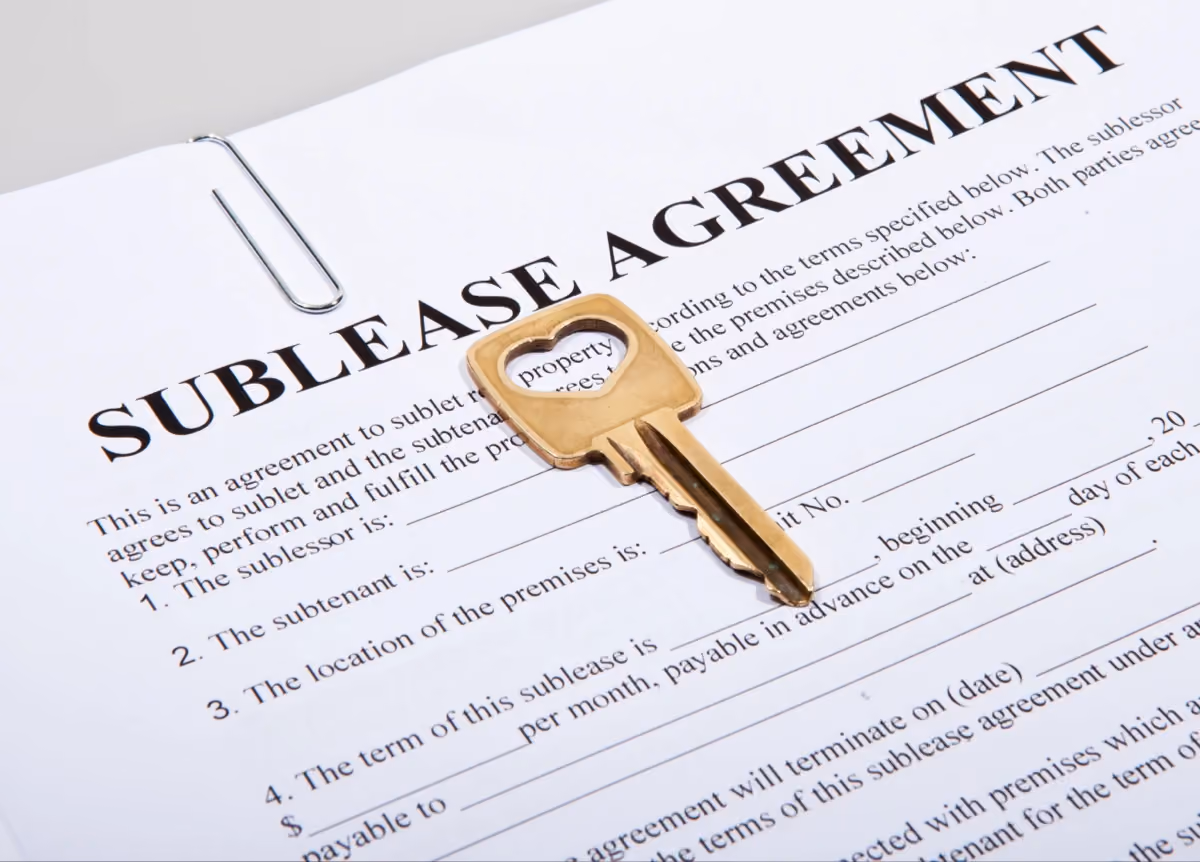 House key sitting on top of a sublease agreement