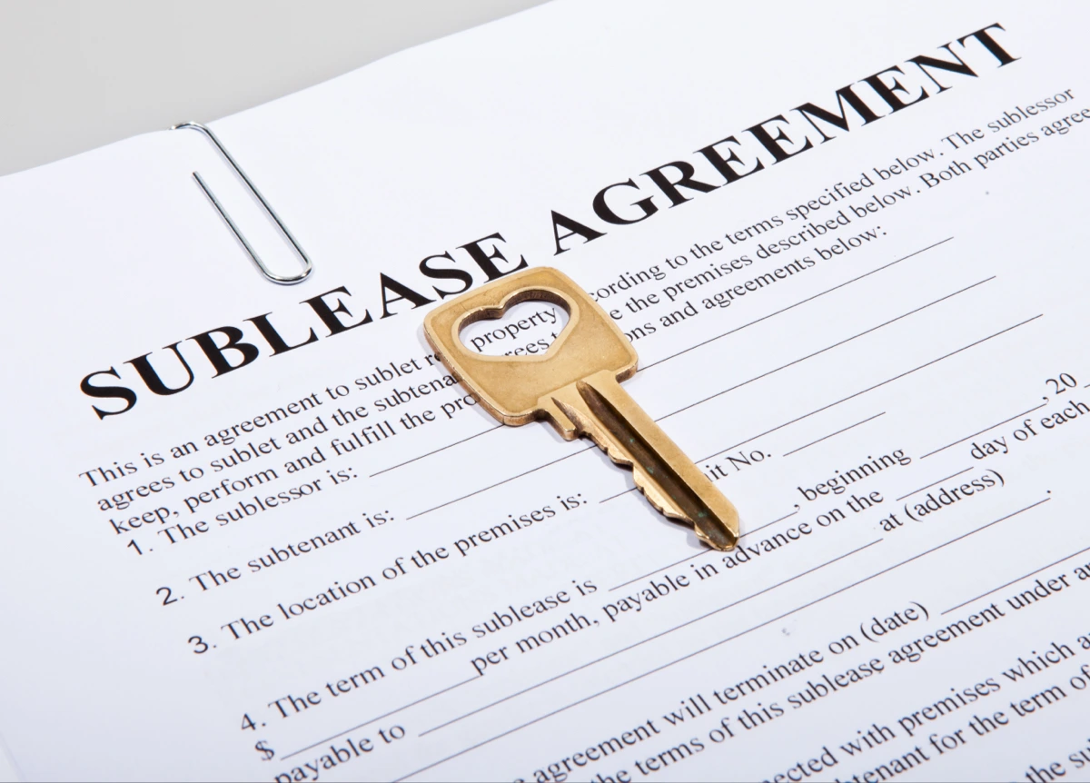 House key sitting on top of a sublease agreement