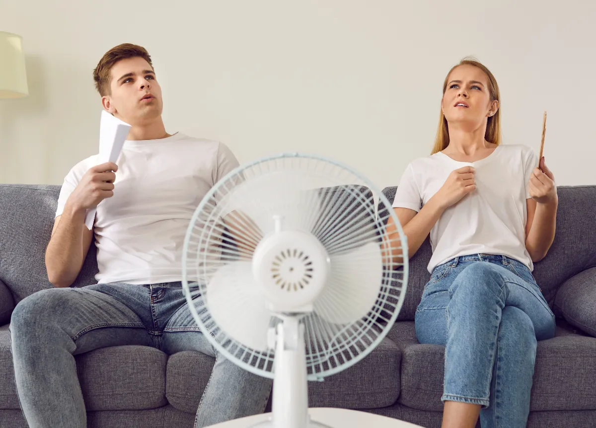 Couple fanning themselves on couch