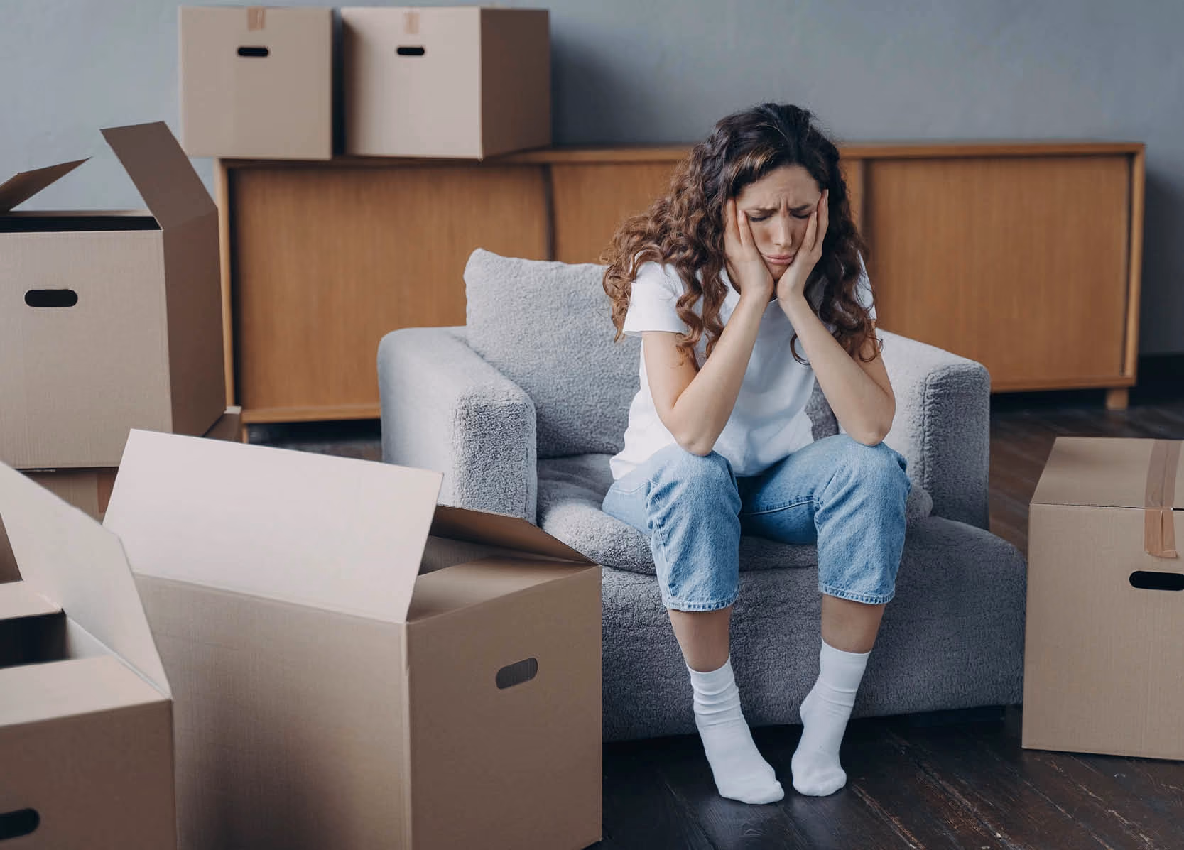 Upset woman sitting with cardboard boxes