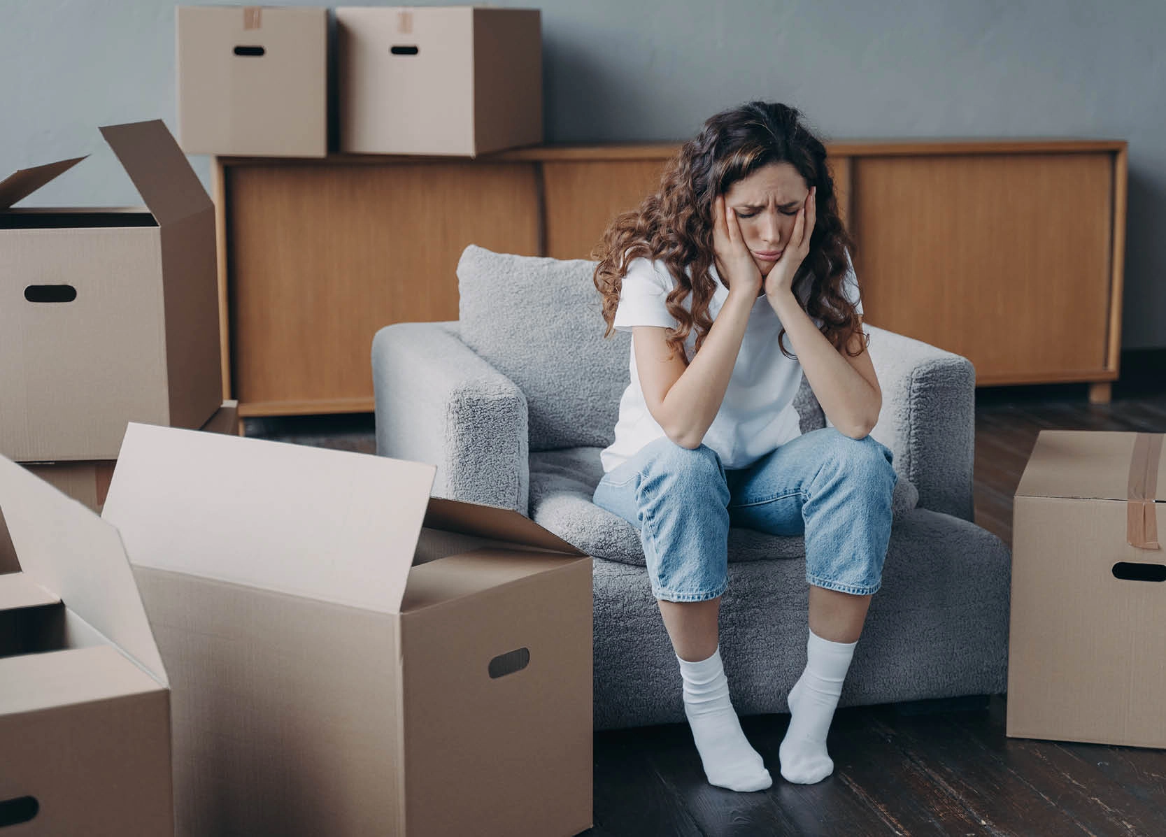 Upset woman sitting with cardboard boxes