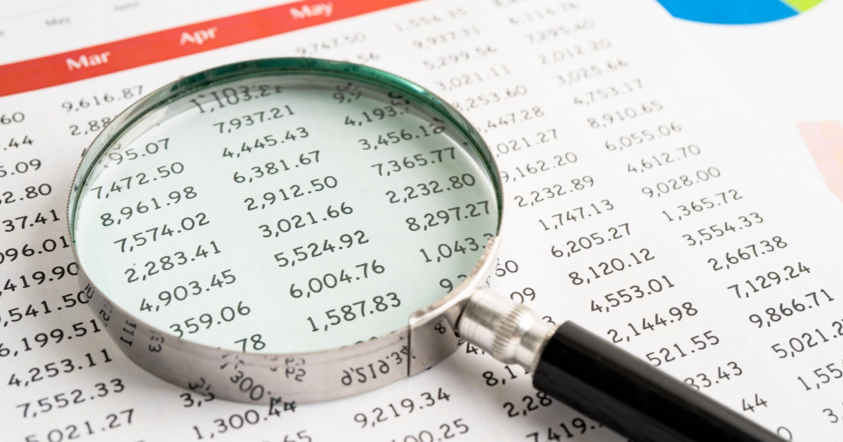 A magnifying glass on top of a sheet of printed accounts