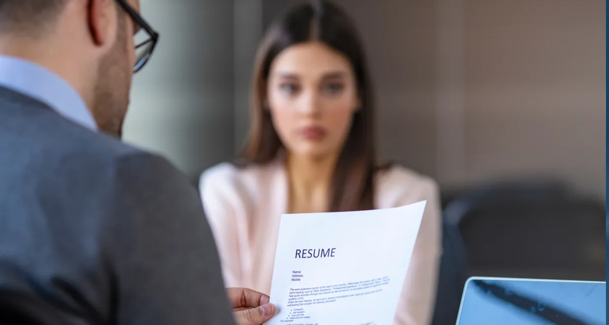 A man holding a resume sitting opposite a woman