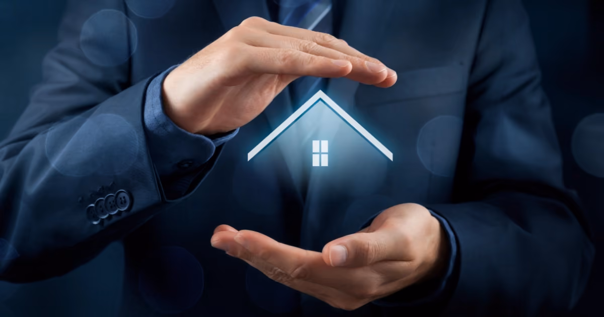 A man wearing a suit with his hands above and below an image of a house