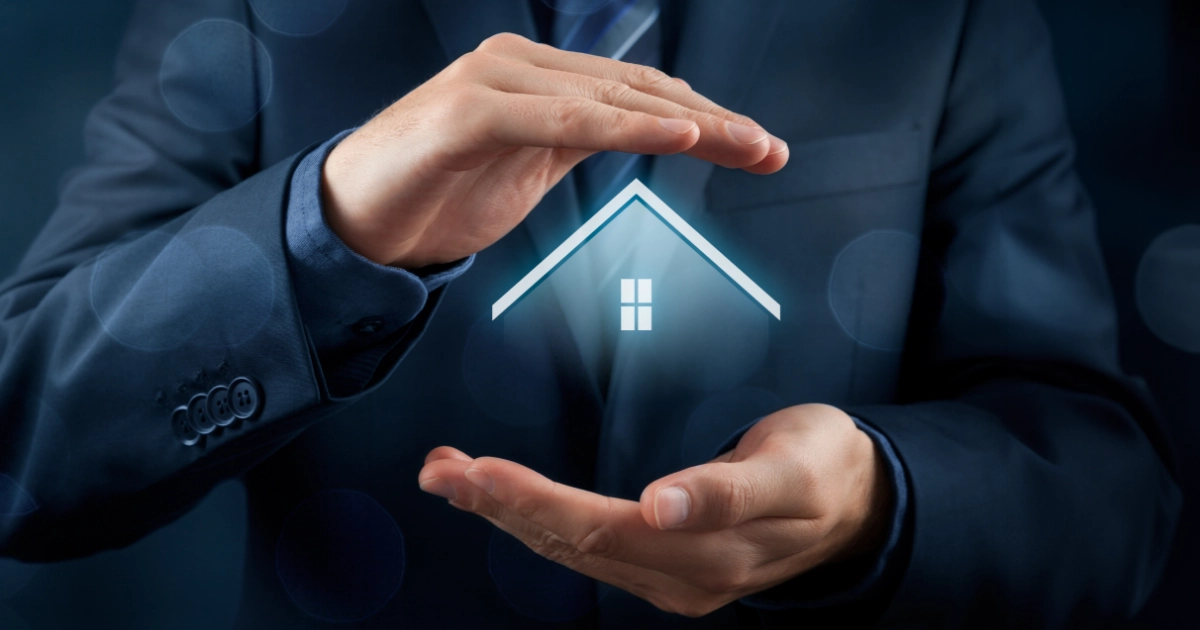 A man wearing a suit with his hands above and below an image of a house