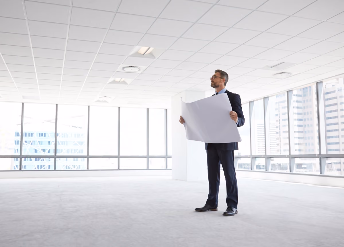 Male architect in empty modern office, looking at plans