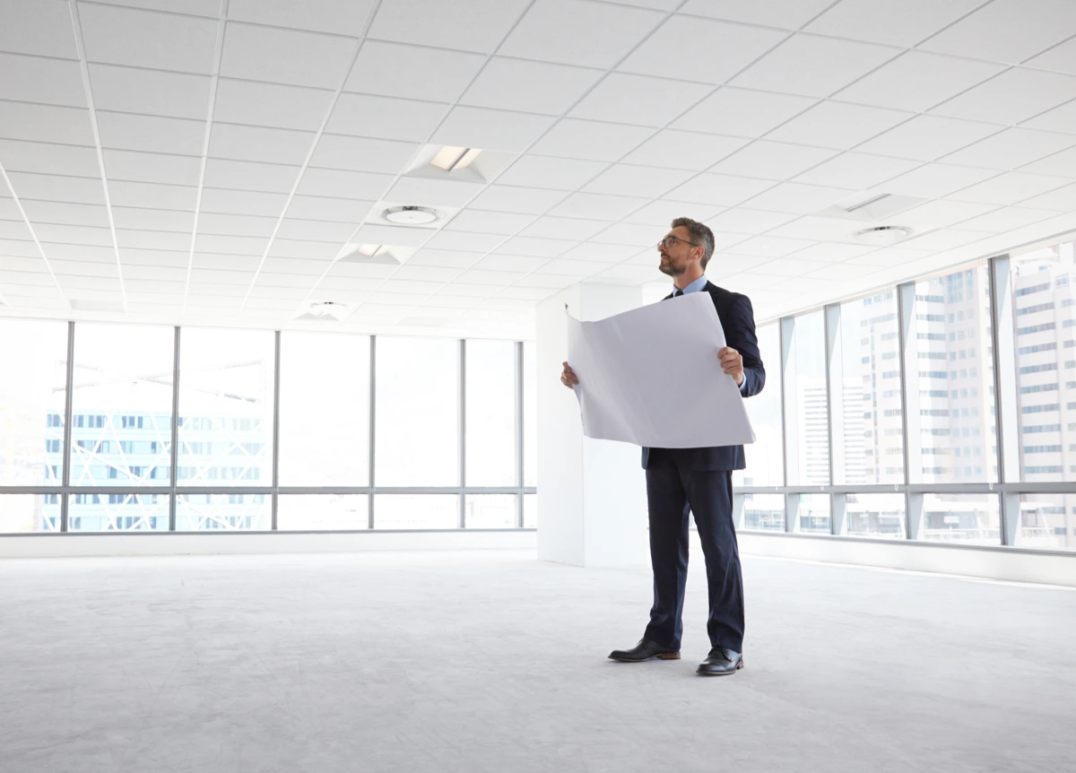 Male architect in empty modern office, looking at plans