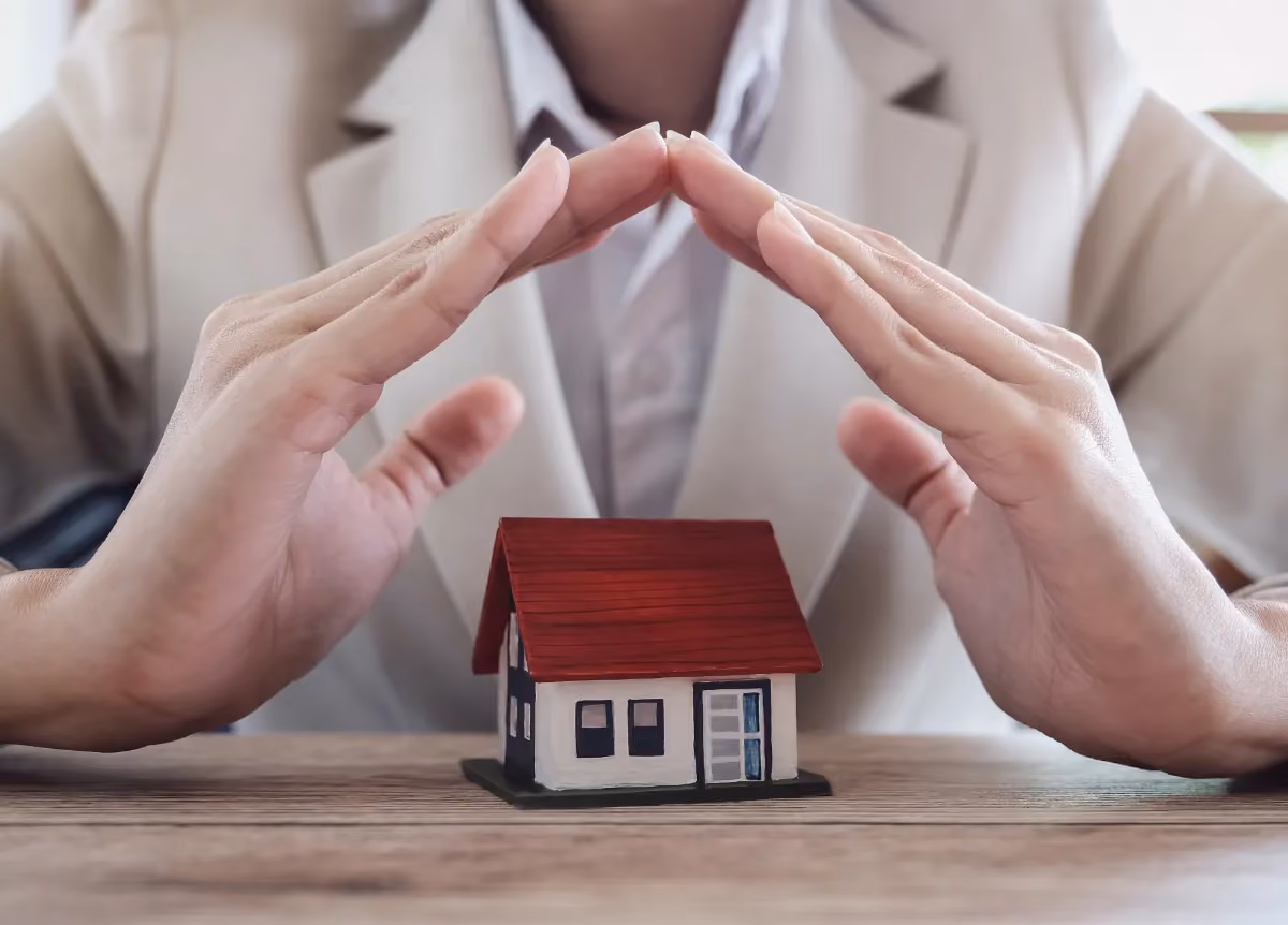 Man holds hands above model of house