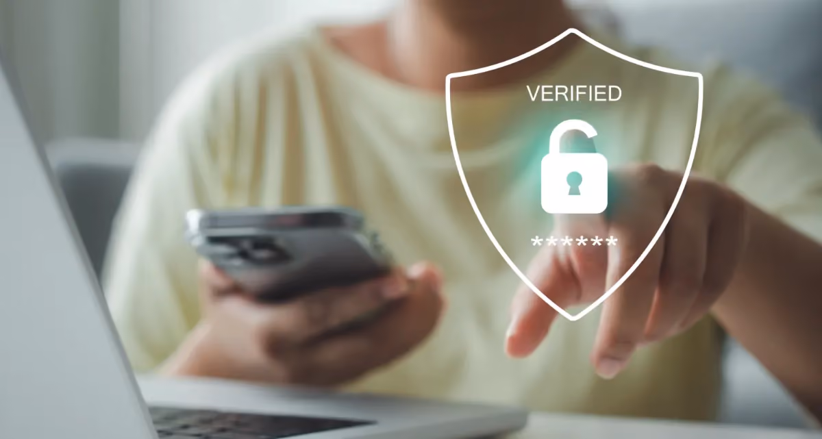 A man looking at a laptop screen with an icon saying "Verified"