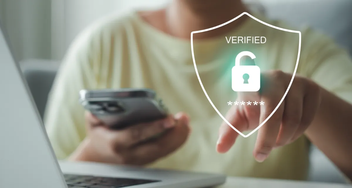 A man looking at a laptop screen with an icon saying "Verified"
