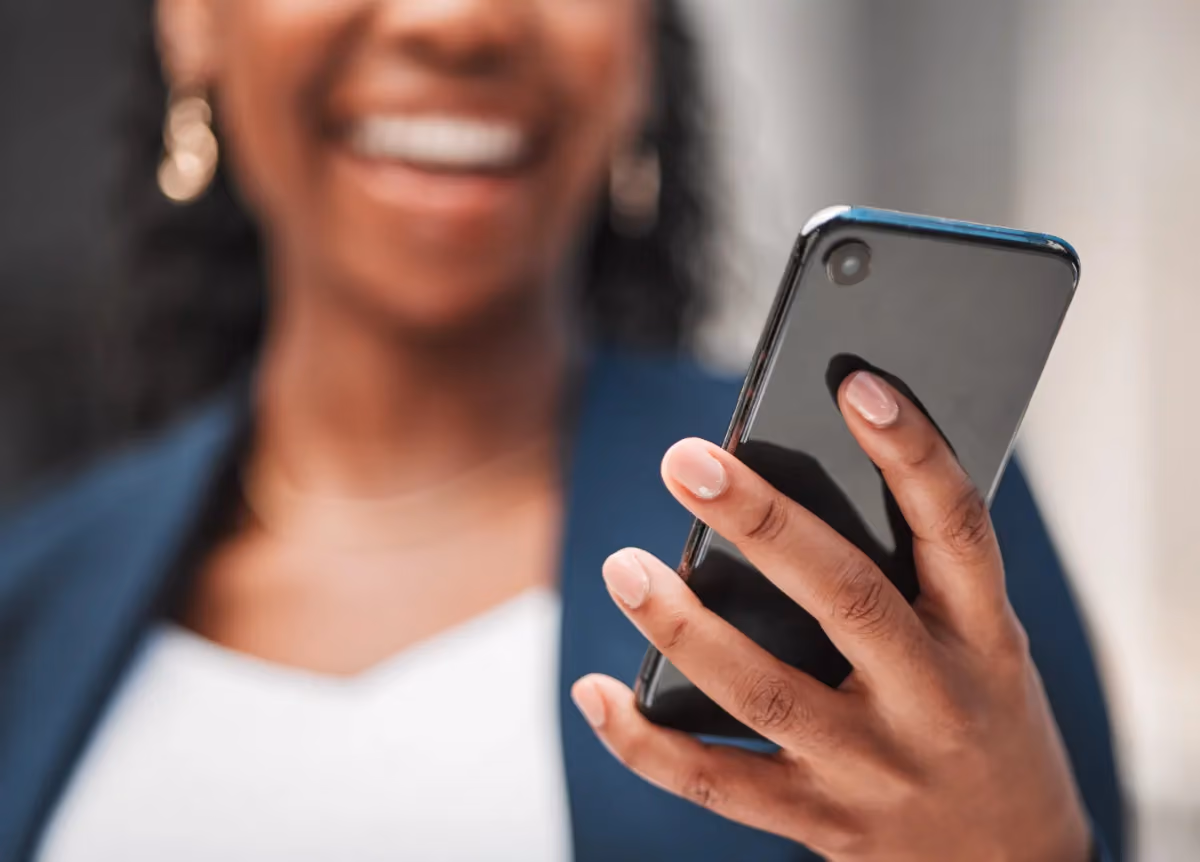 Woman smiling at smartphone in her hand