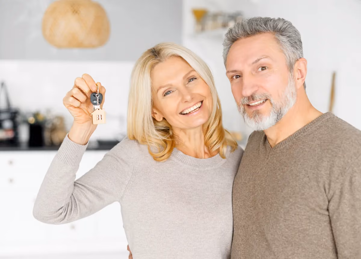 Happy middle-aged couple holding house keys