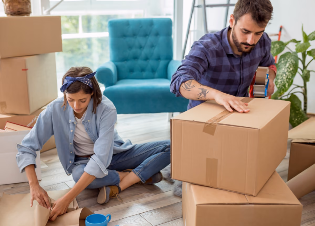 Man and woman packing their possessions into cardboard boxes, getting ready to move