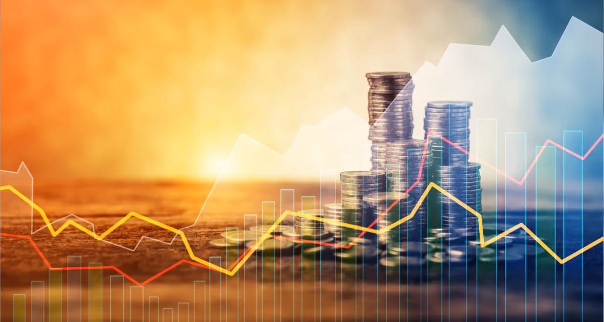 Graph trend lines in front of a stack of coins and a sunset