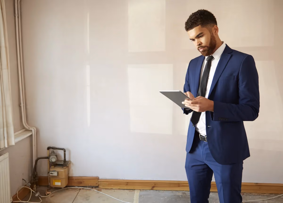 Man in suit holding a clipboard in an empty apartment