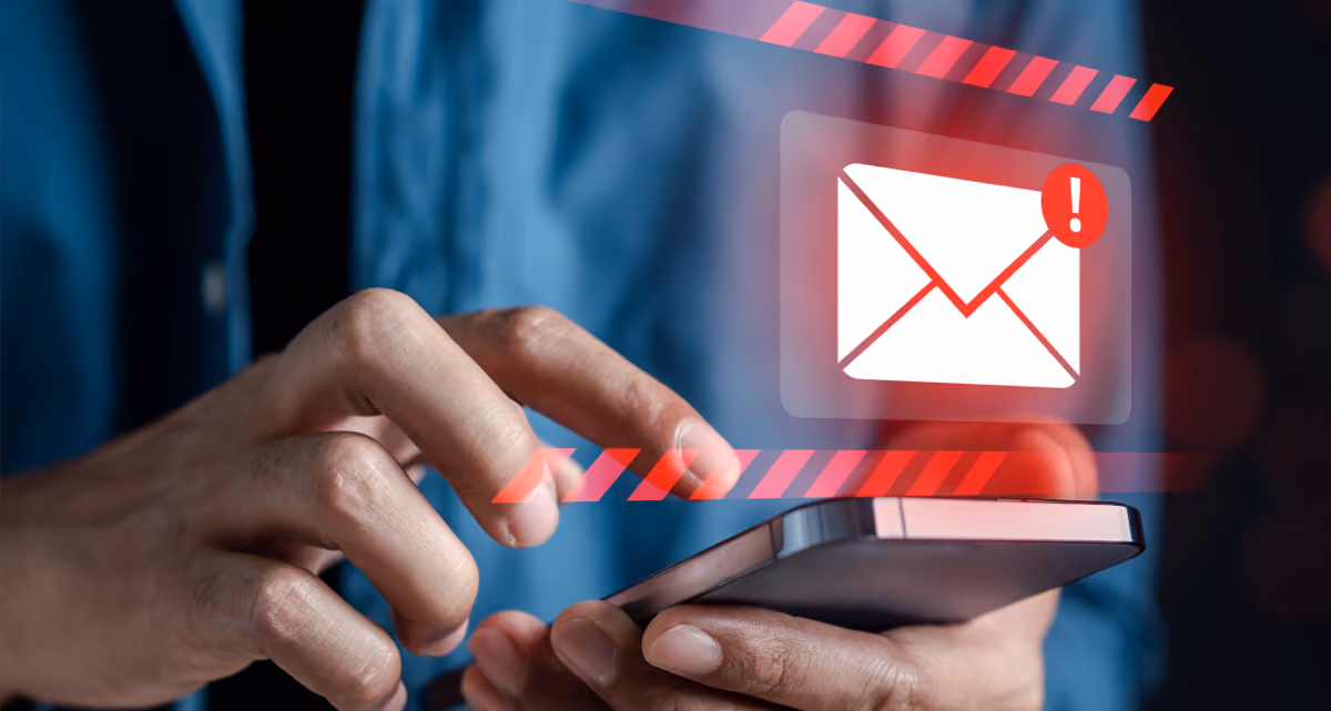 A person using their cell phone with a red e-mail icon with a red exclamation mark hovering above it