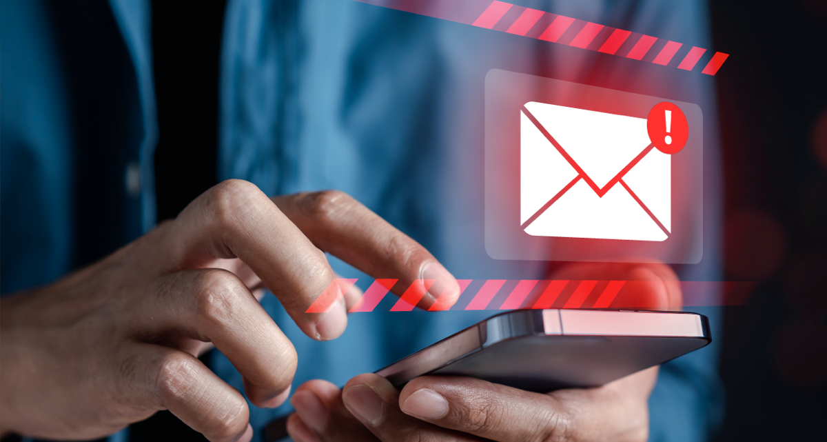 A person using their cell phone with a red e-mail icon with a red exclamation mark hovering above it