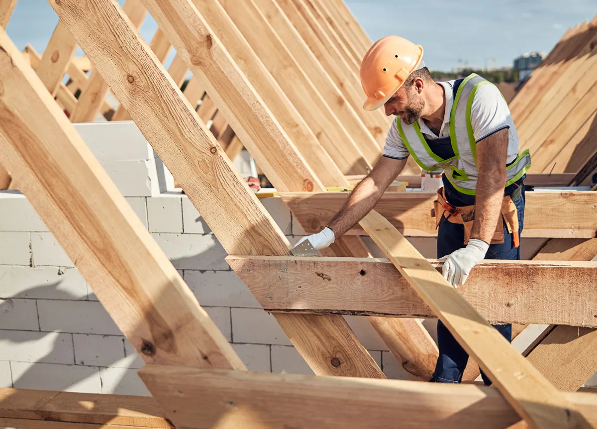 Construction worker focusing on a roof truss