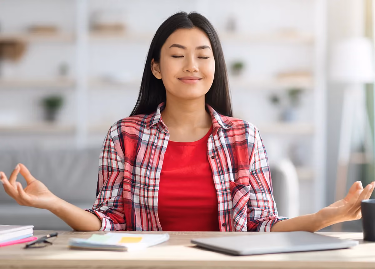 Woman meditating in her home office