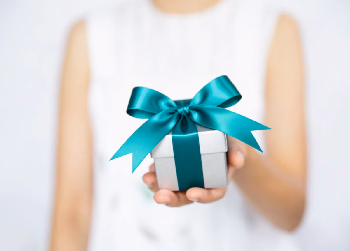 Woman handing the camera a wrapped gift