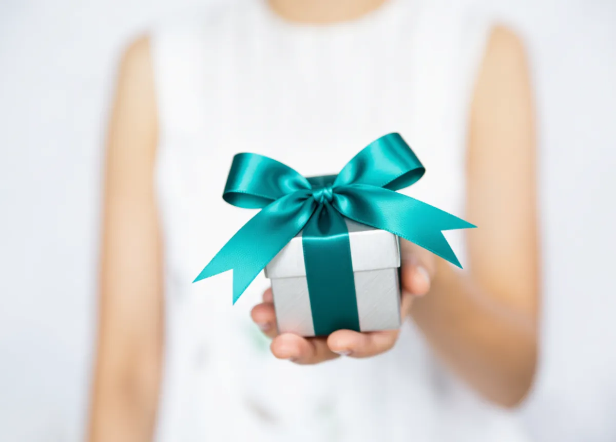 Woman handing the camera a wrapped gift