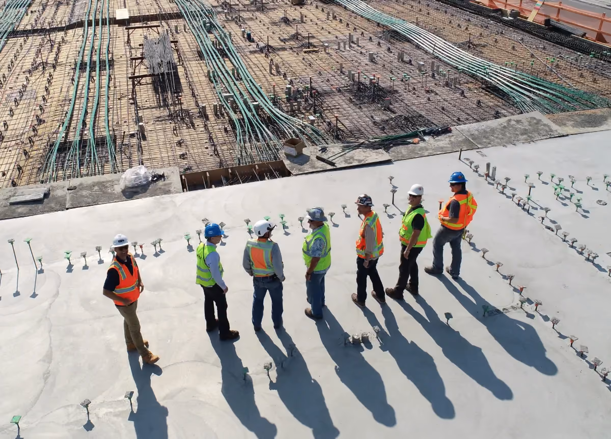 Construction workers standing around large construction site