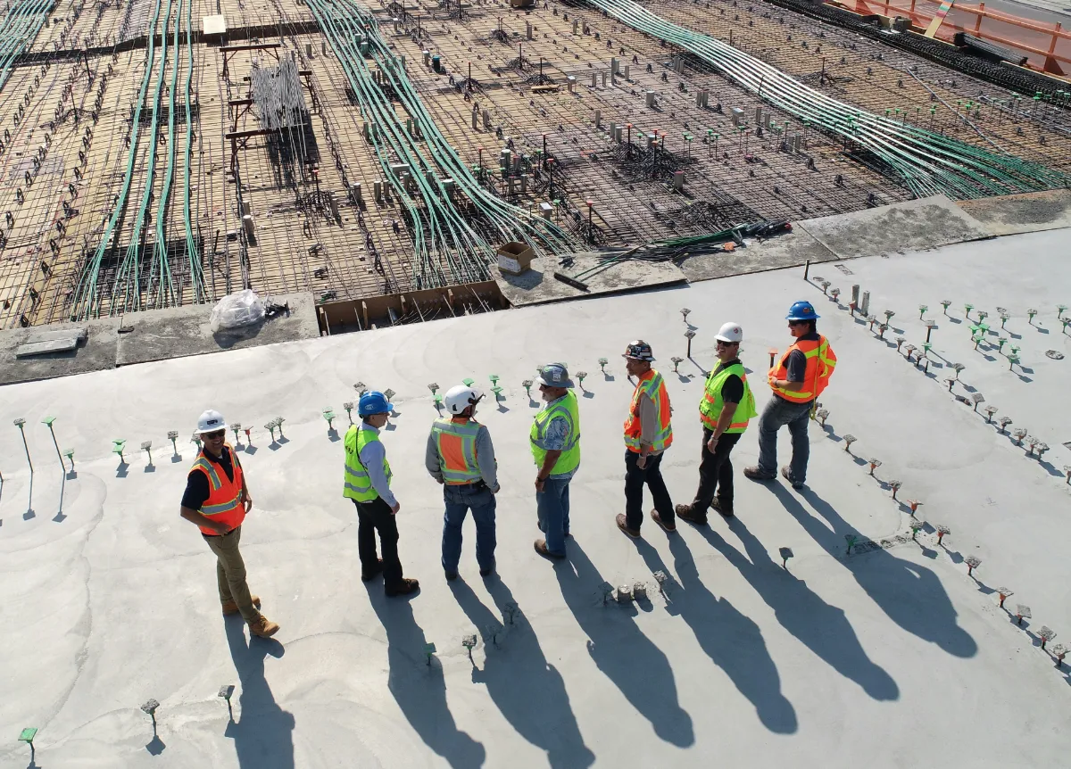 Construction workers standing around large construction site