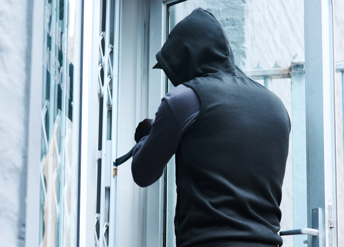 Hooded man breaking into house