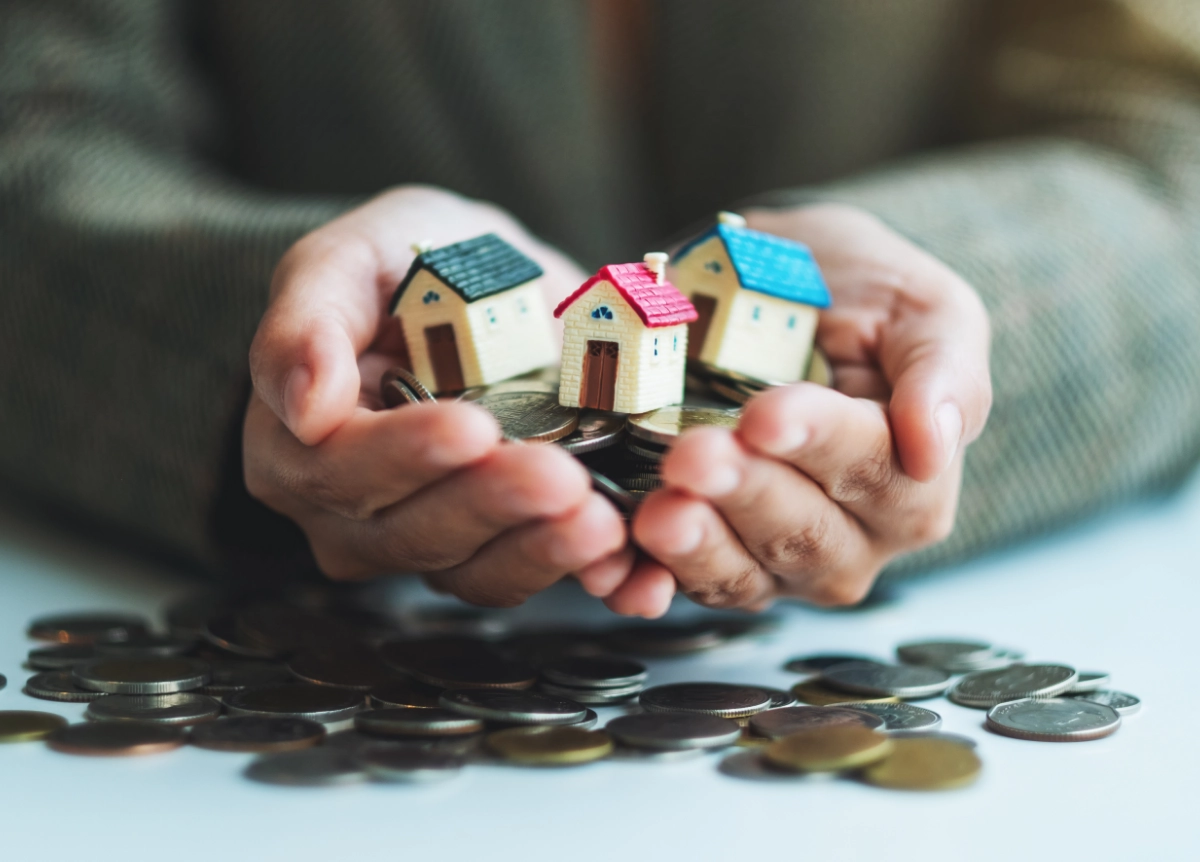 Person holding little models of houses