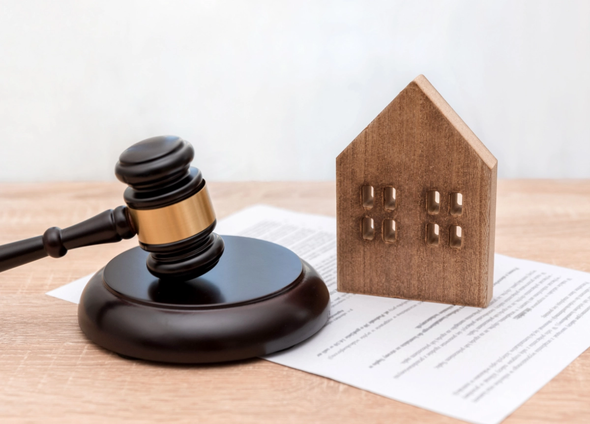 Gavel next to a model of a house