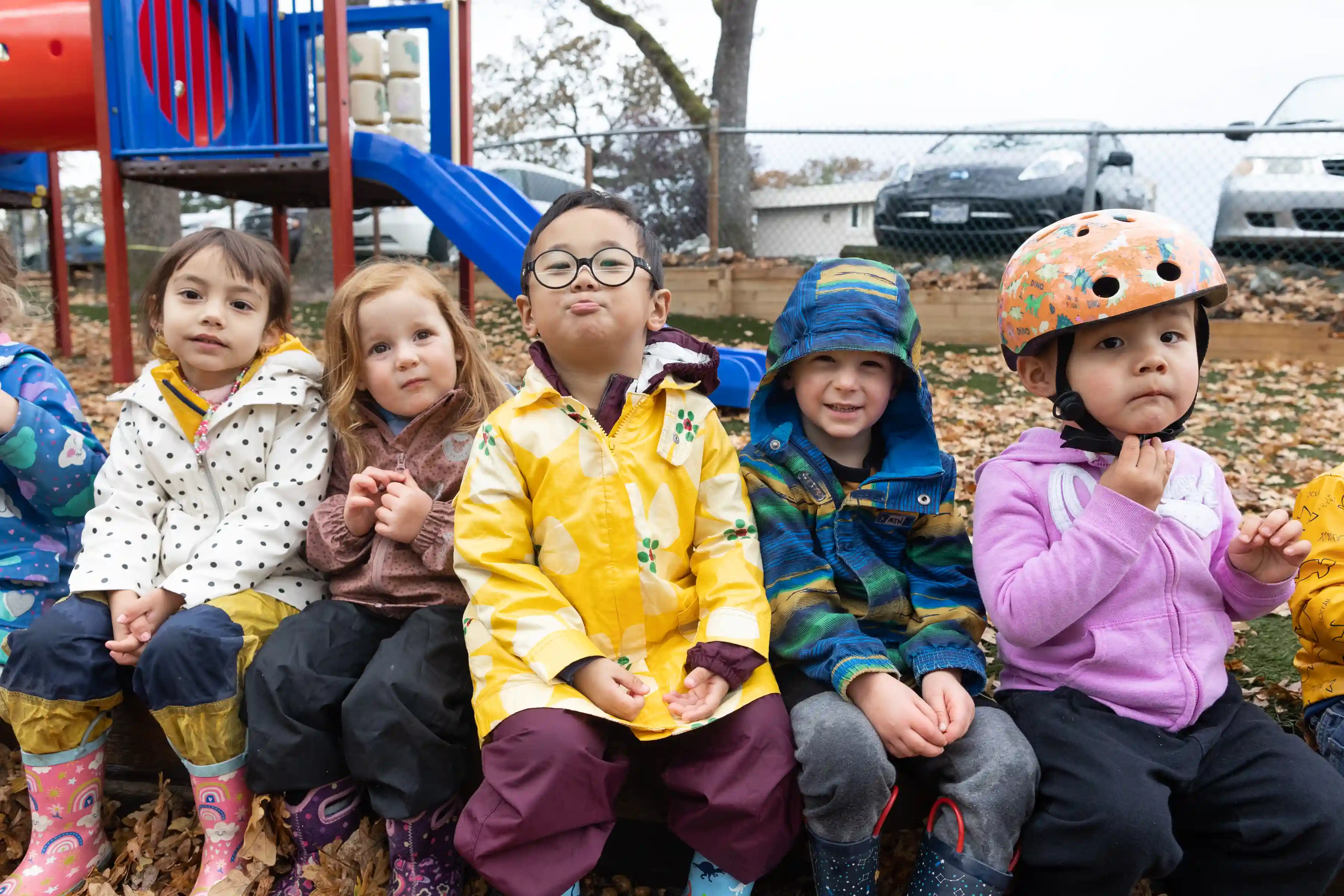 A group of early childhood education students sitting in a playground
