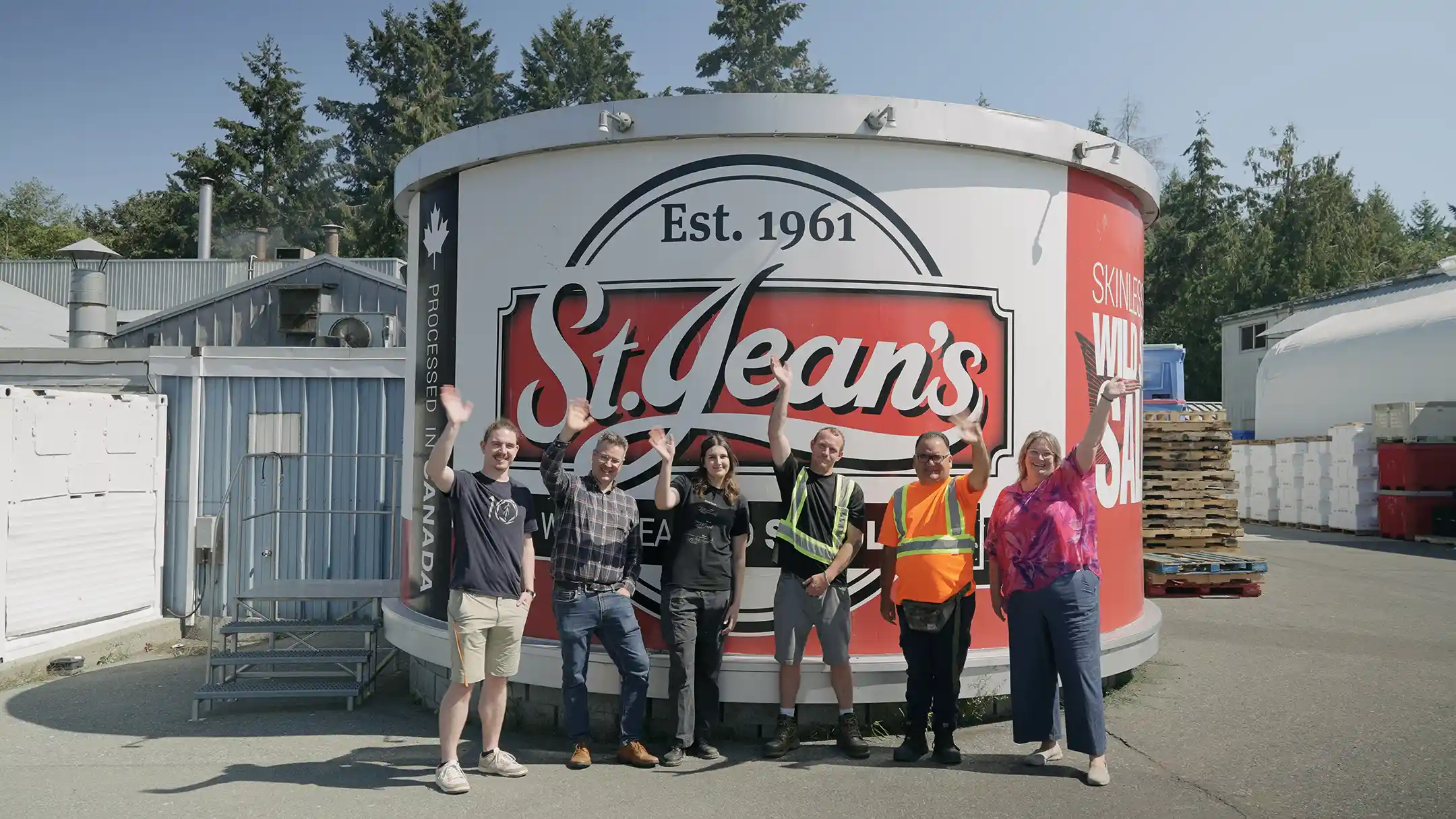 CanAssist and St. Jean's Cannery staff posing in front of a gigantic can