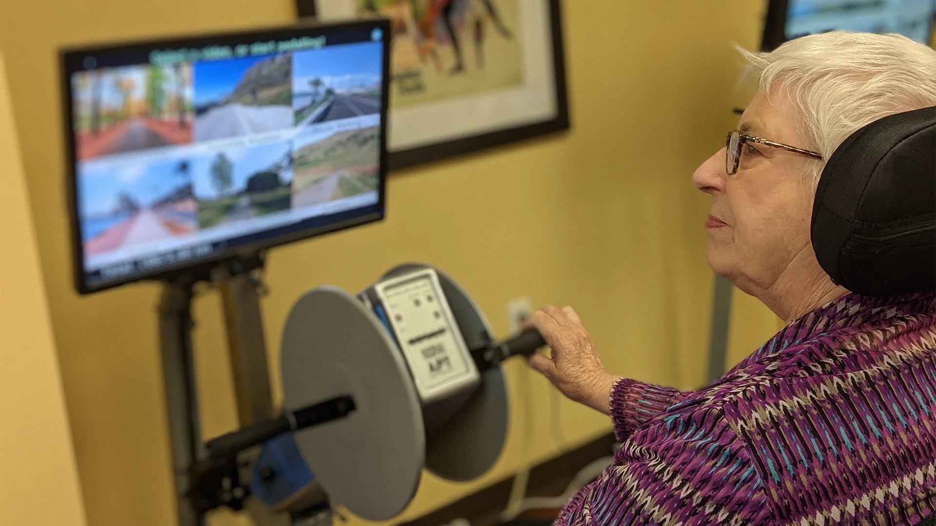 Someone using CanAssist's Motivex bike riding simulator assistive technology