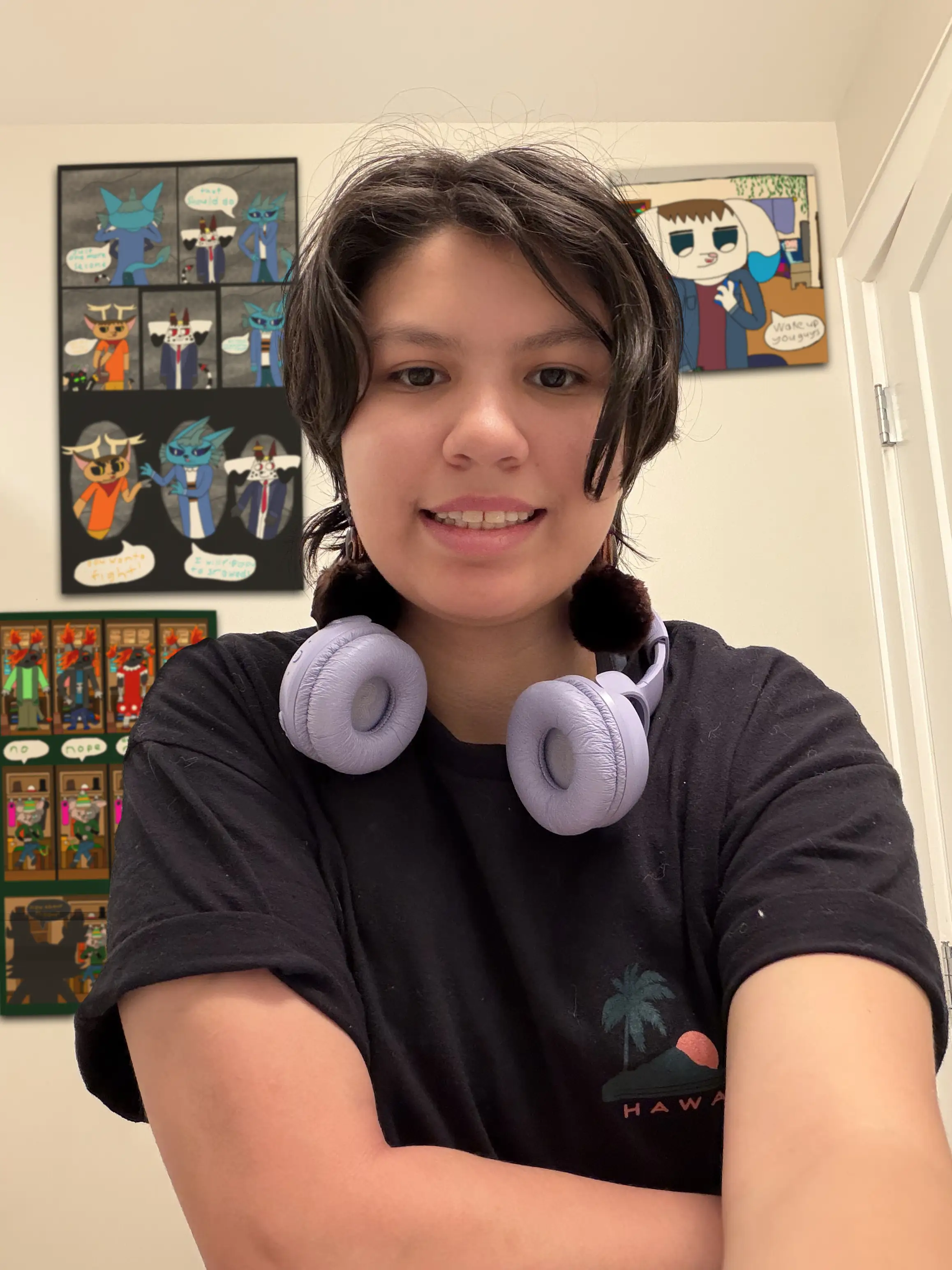 Artist wearing headphones standing in front of wall with comics and storyboards